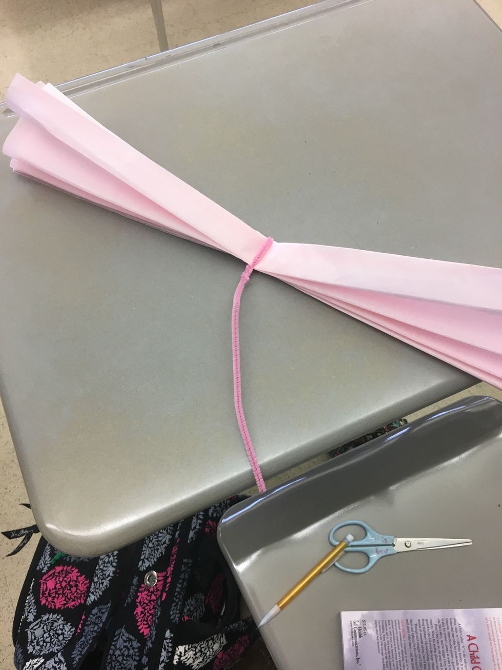 Wrap the pipe cleaner around the middle of the flower and twist it so it stays in place