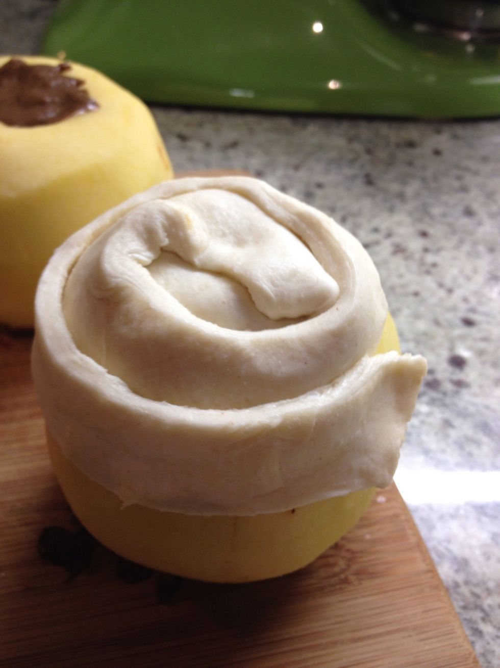 Wrap the rest of the strip around the apple making sure to overlap the pastry and press down firmly at the overlap. If a strip finishes, attach another and keep going until the apple is fully encased.