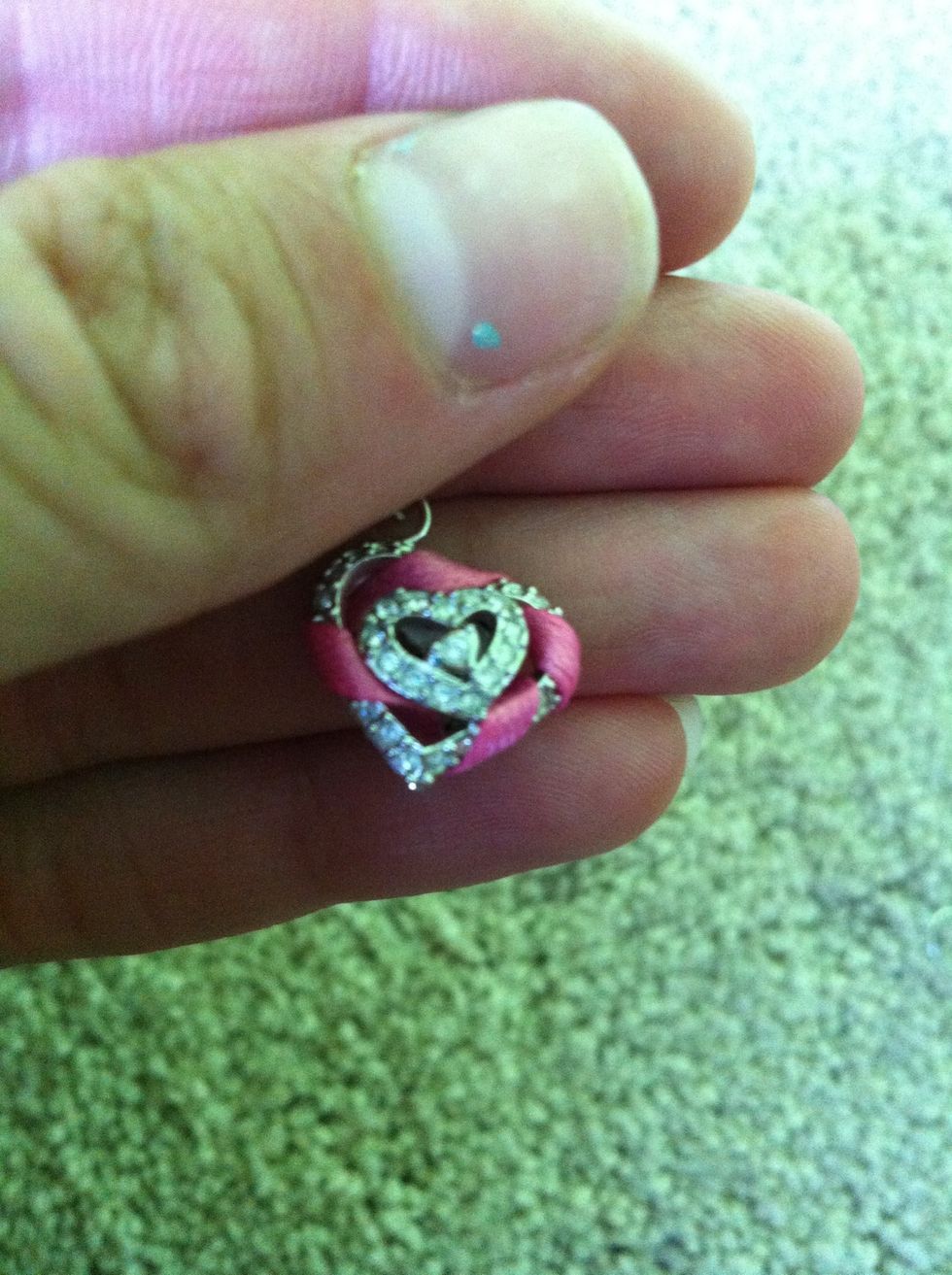 Wrap the ribbon in between the gaps all around the charm.