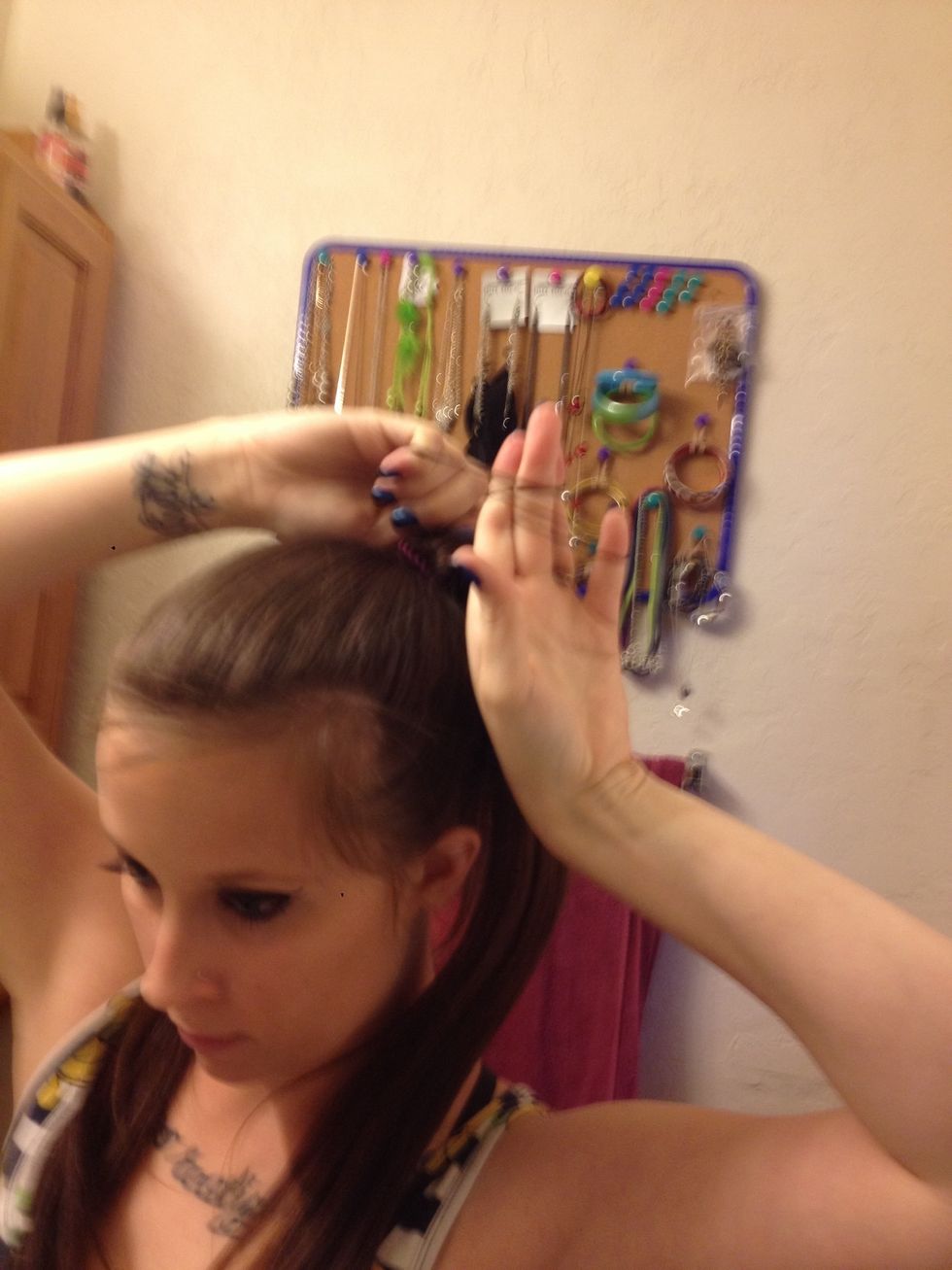 Wrap the single pice of hair you were holding around your fingers or hand like I am doing and tuck it under the the hair you just pulled up