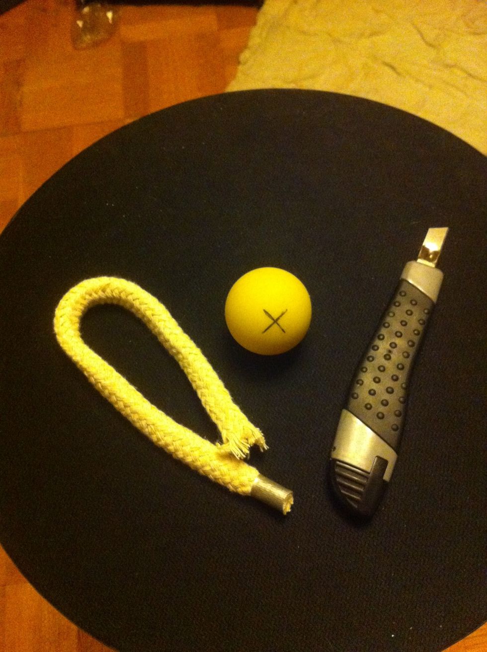 Wrap the tape around one end of the rope or cord. With a hobby knife cut a cross in the ball on opposite sides. Thread the rope through the ball and make a knot.