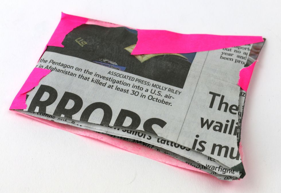 Wrap the tape over the newspaper to the back.