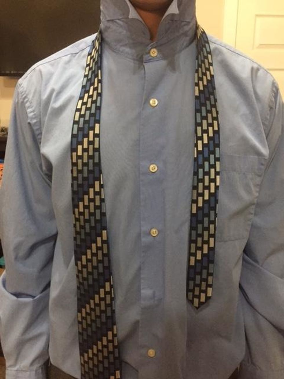 Wrap the tie around neck. The wide end should be about twice as long as the small end.