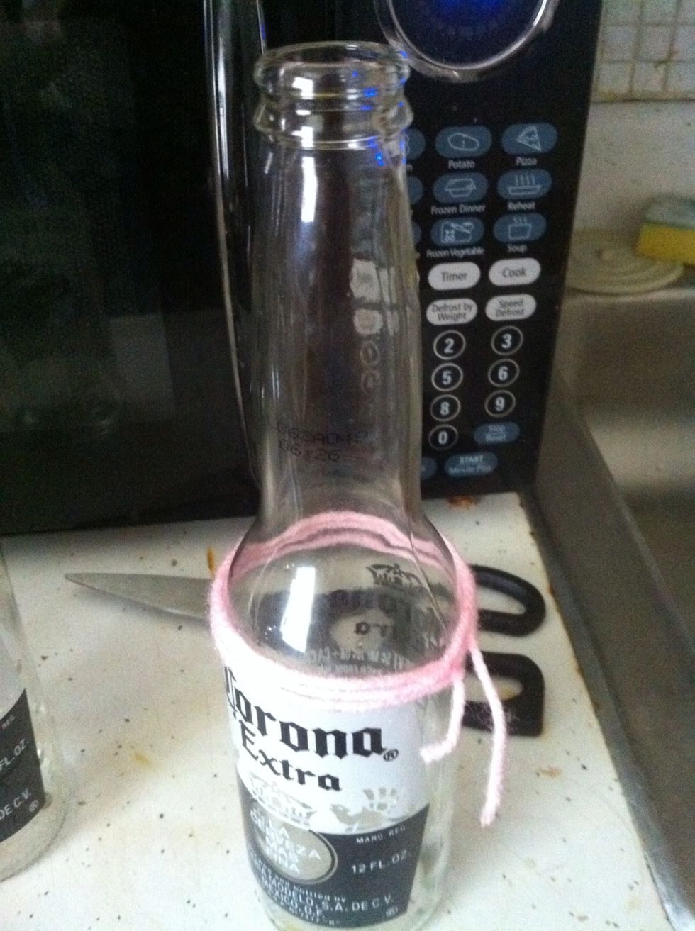 Wrap the yarn around the bottle several times . You need to place the yarn on where you would like the bottle to crack (I did it three times and tied knots to make it stay on there better)