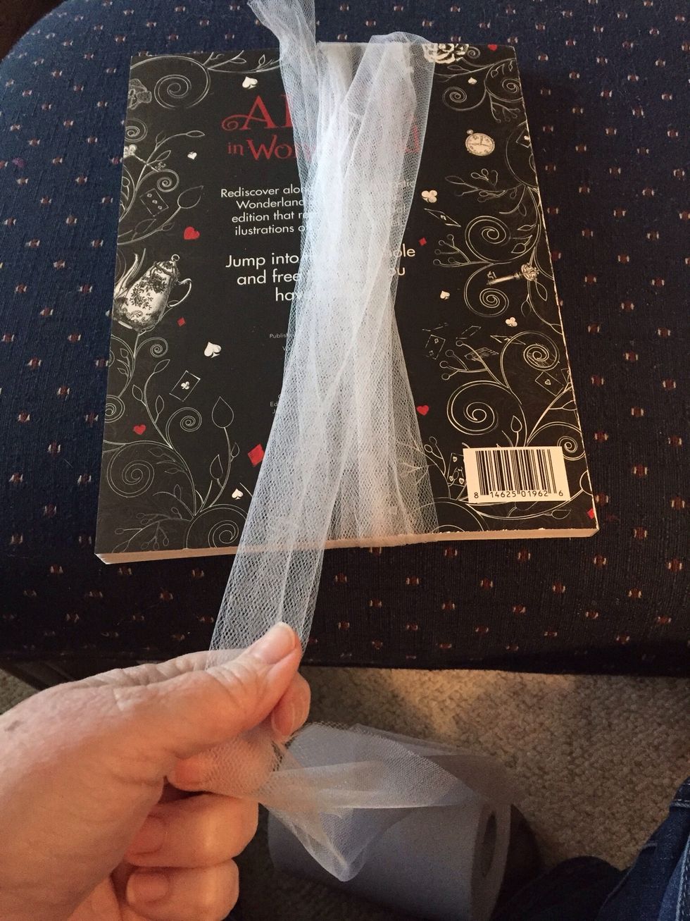 Wrap tulle around book or magazine.  Pick size you would like...magazine vertically will be a larger Pom Pom.