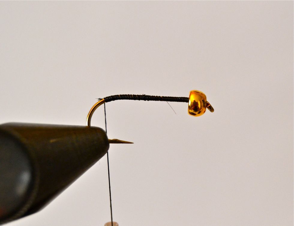 Wrap your black thread covering the shaft from the eye end back to where the shaft begins to curve down. This is where you'll begin making your goose biot 'tail.'