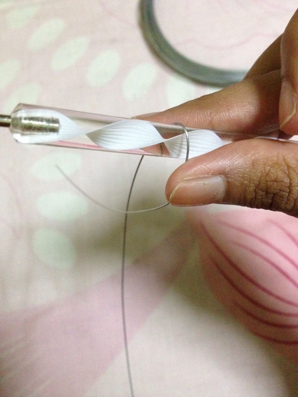 Wrap your wire around a cylindrical surface. This is to create a round surface which will then be shaped into a petal.