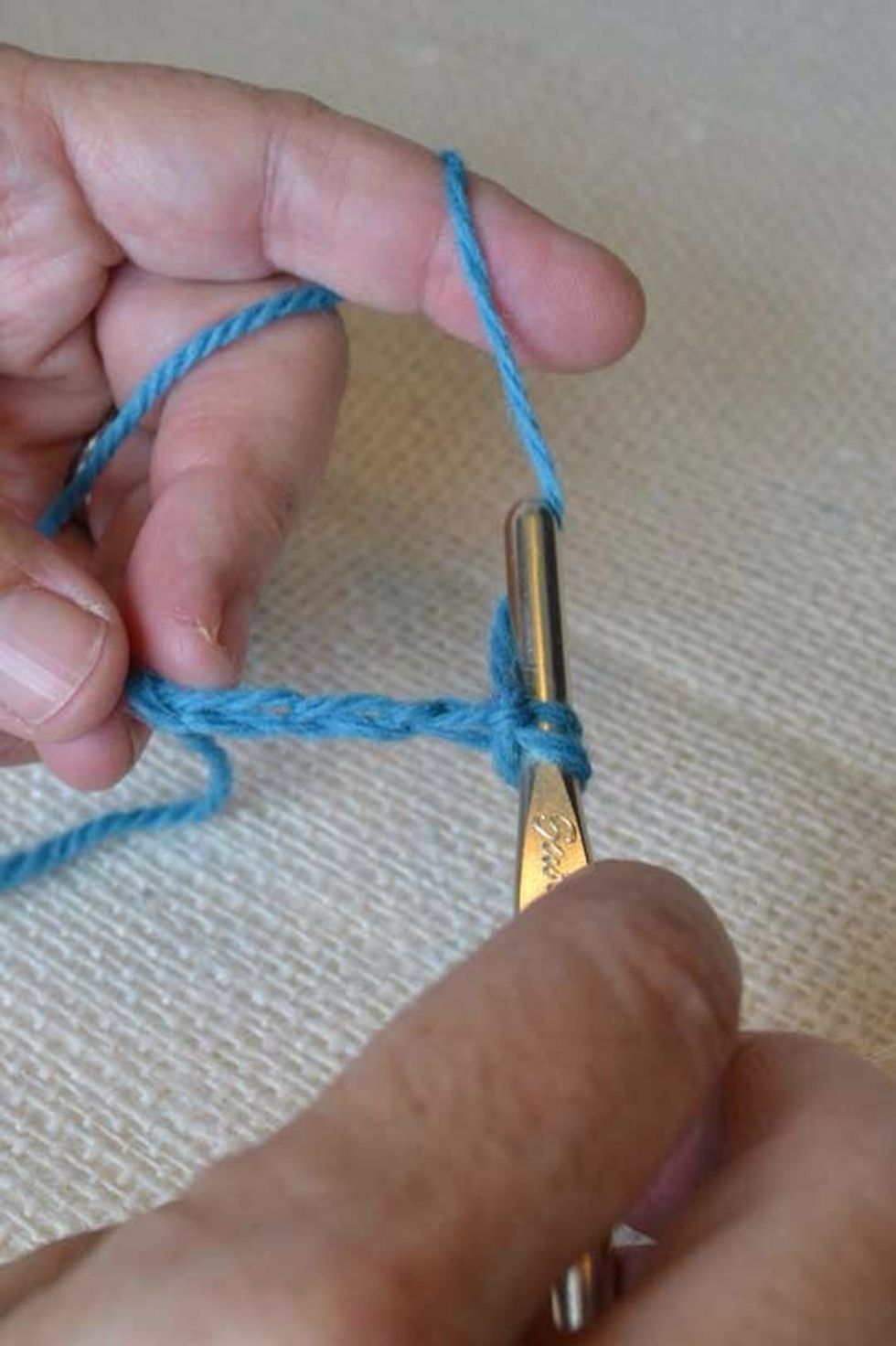 Yarn over, catch with your hook, and draw the yarn through the V.