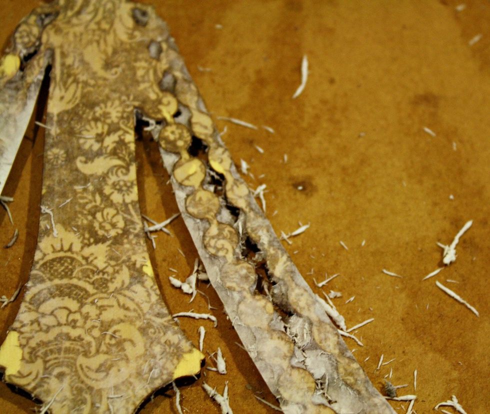 You are going to keep on spritzing and rubbing over the entire piece. You can see there, on the "beaded" area of the wooden chandelier, any excess paper will start to just crumble right off.