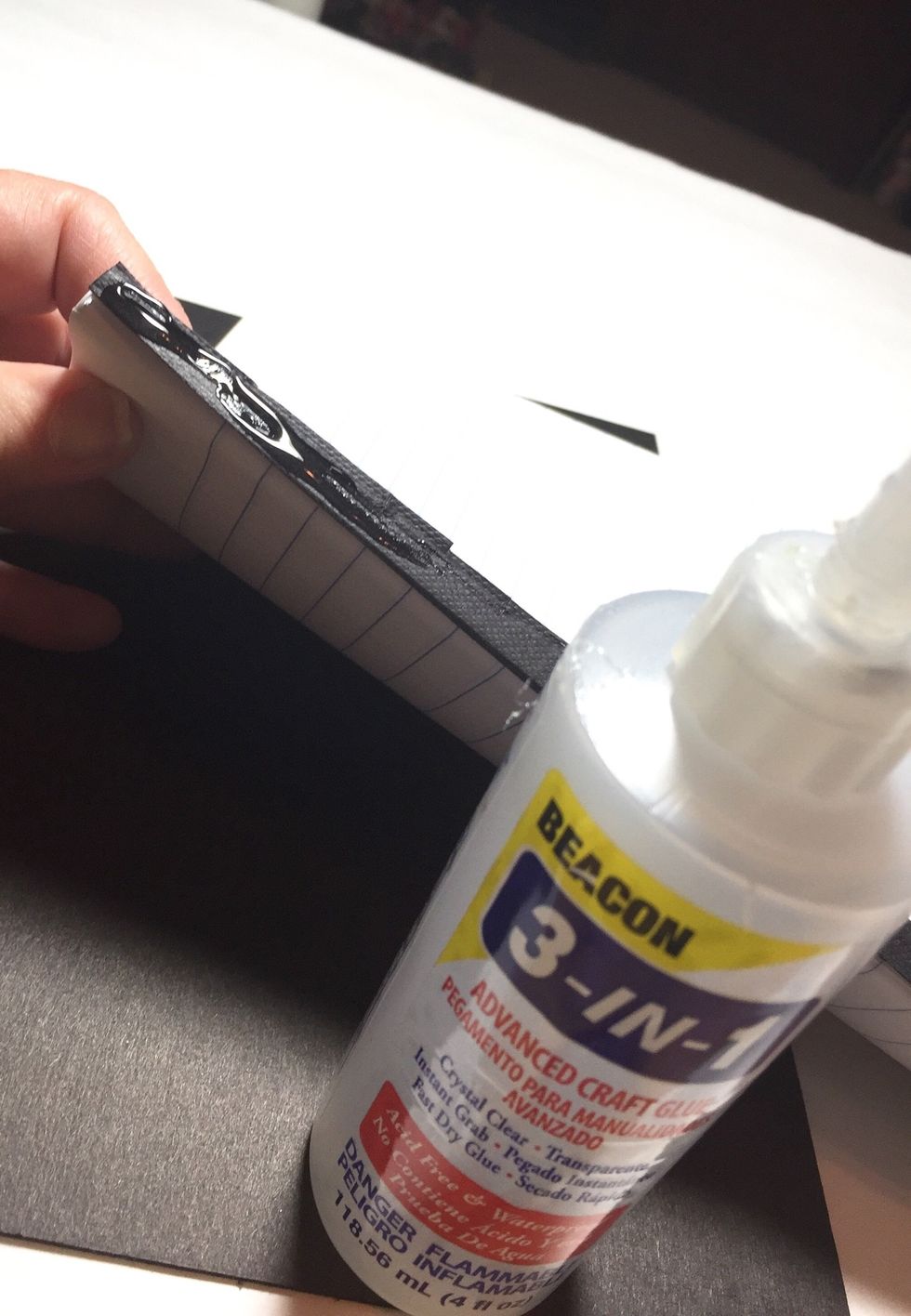 you are now ready to add the pages to your journal cover. apply a generous line of glue along the spine piece left on the composition book pages.