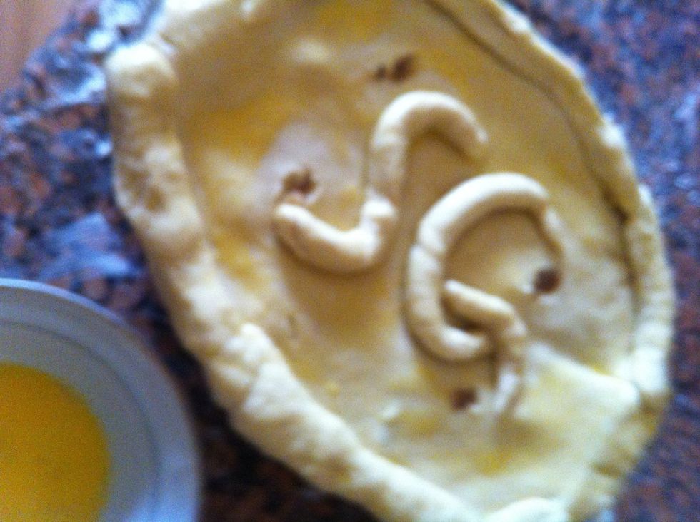 You can design it as u want with the extra dough, then whisk an egg and cover the dough with it using a cooking brush or anything.