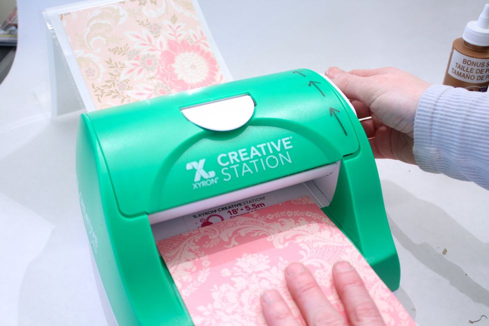You can glue your paper on with Tacky Glue, but I recommend this sweet little Machine the Xyron Creative Station 5 Inch. If gluing- glue the roll first then add the paper