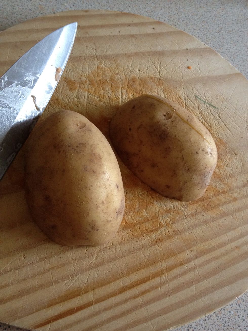 You can peel your potatoes if you want, but I prefer the skins on. Next cut them in half. Do the same with your sweet potatoes. You can cut the really pointy ends off if you want as they tend to burn.