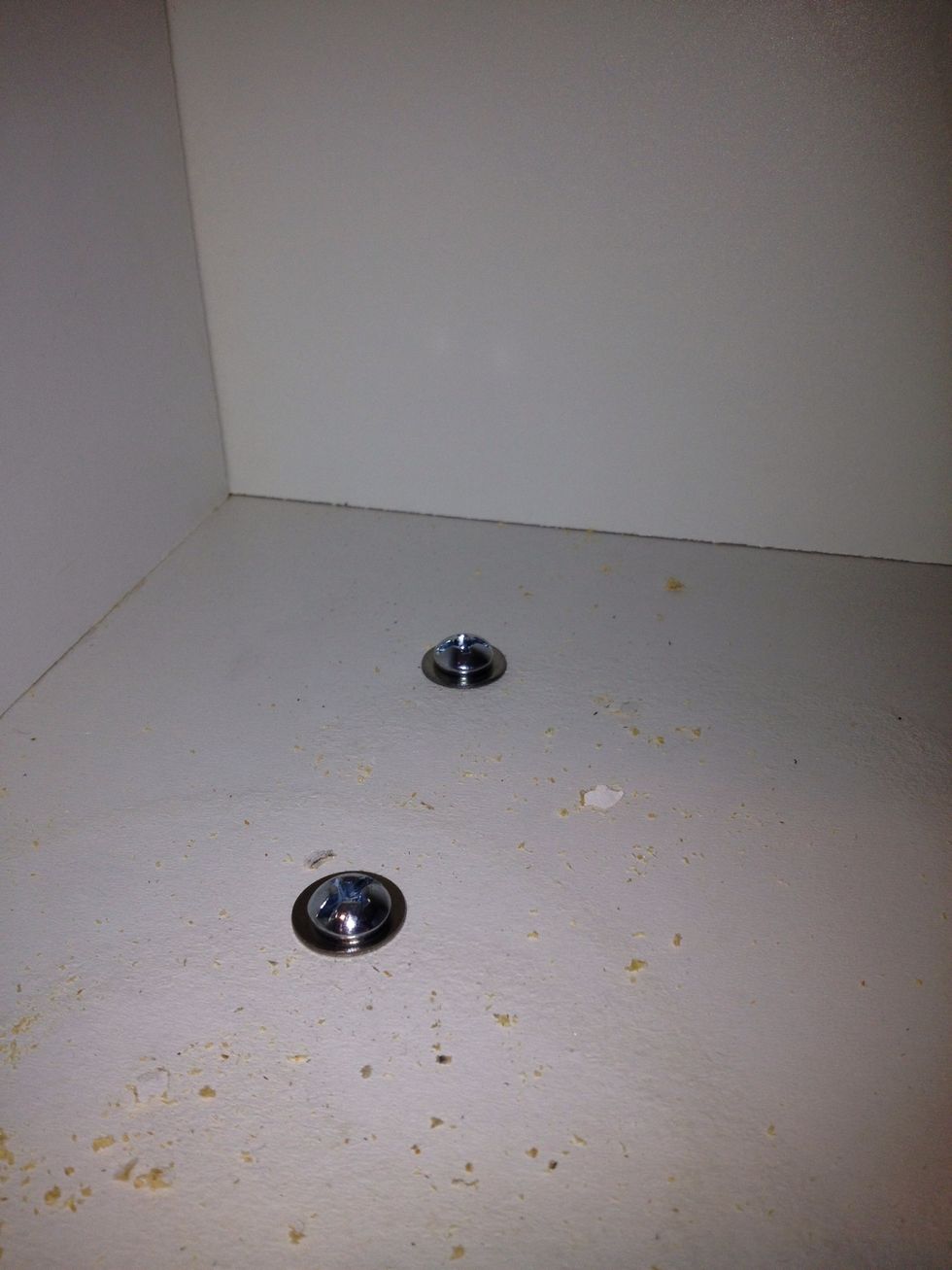You can put both bolts through the cabinet floor although it may be easier to just do one first.
