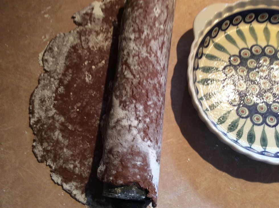 You can use the rolling pin to lift the dough off the work surface and then unroll the dough over the pie plate or you can carefully lift the dough up with your hands and place it in the pie plate.