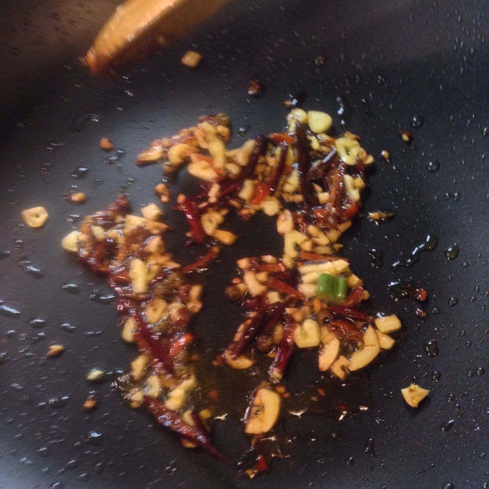 You can use the same pan and stir fry all the spices we prep. Garlic, green onion, chilli pepper and the spices in the peanut bag. (Wait, it's not peanut's turn yet so don't add peanut here.)