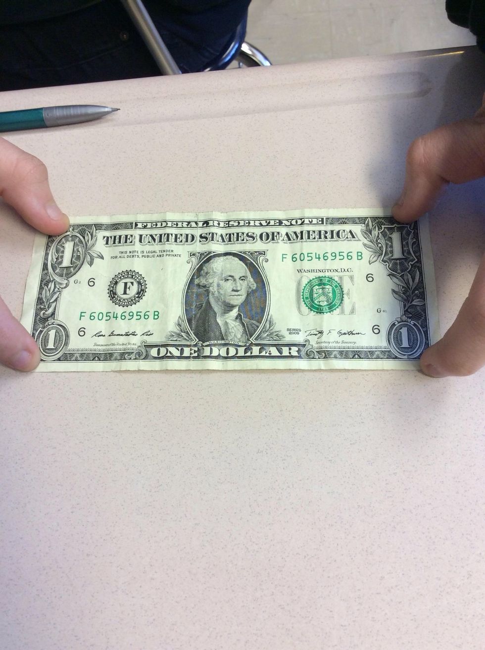 You lay the bill face-side up, horizontally (long way).