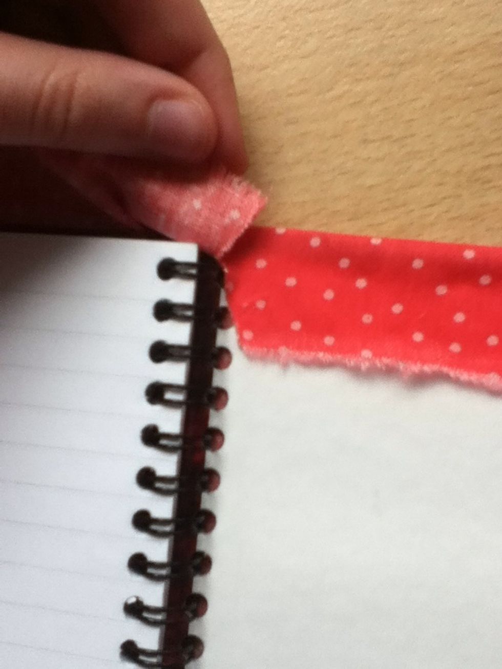 You'll have some fabric covering the spiral binding; cut it a line in it as shown. (Don't cut too far, or it will look messy).