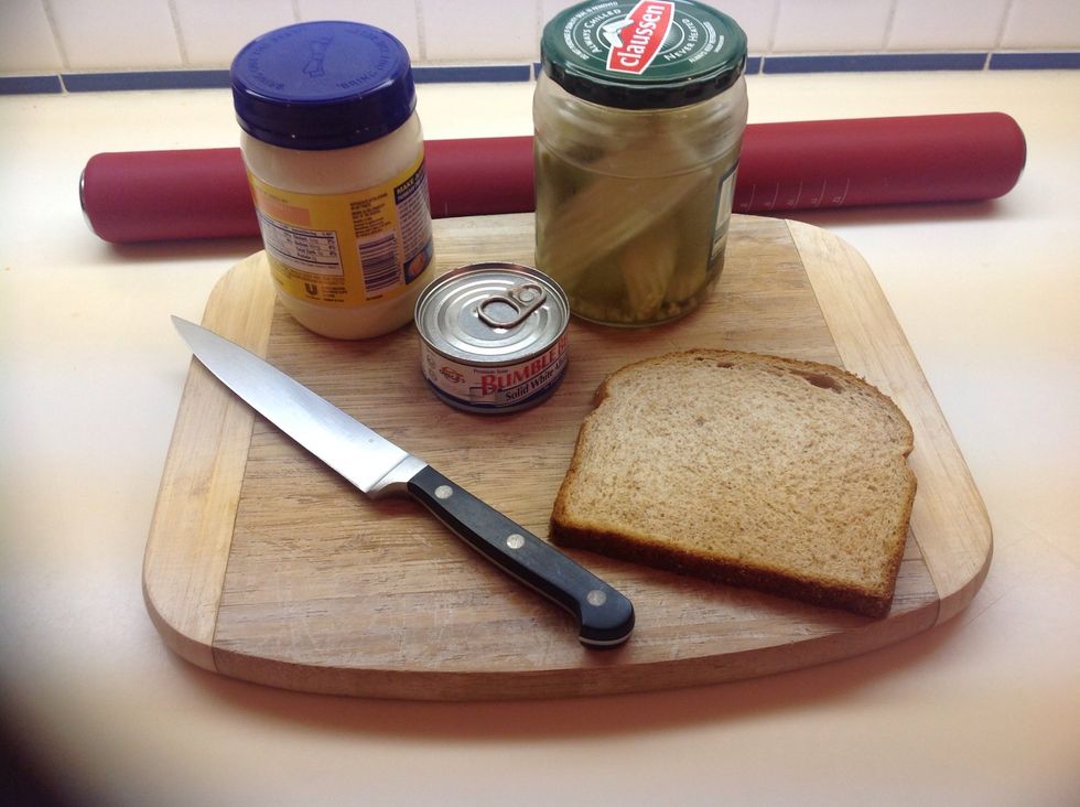 You'll need a 3 ounce can of tuna, mayonnaise, pickles, whole wheat bread, a cutting board, a rolling pin, and a sharp knife.