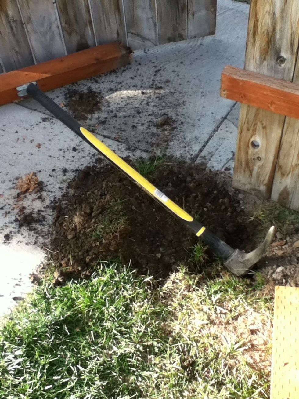You may need a pick to dig in hard soil and a sledge hammer to break the concrete. Remove soil and debris. Wear your safety glasses.