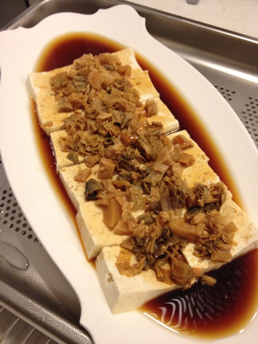You may steam it for a further minute to heat up the soya sauce. The reason for adding soya sauce later rather than at the beginning is so the tofu won't get too salty and retain it's original flavor.