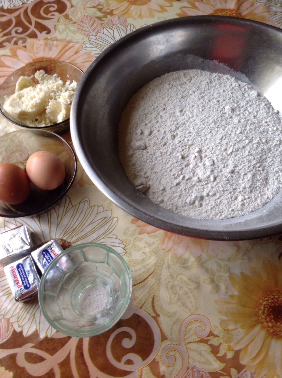 You need 1 kg of white flour, three cubes of yeast, 2 eggs, a pinch of salt, salty sheep's cheese, a quart of water.