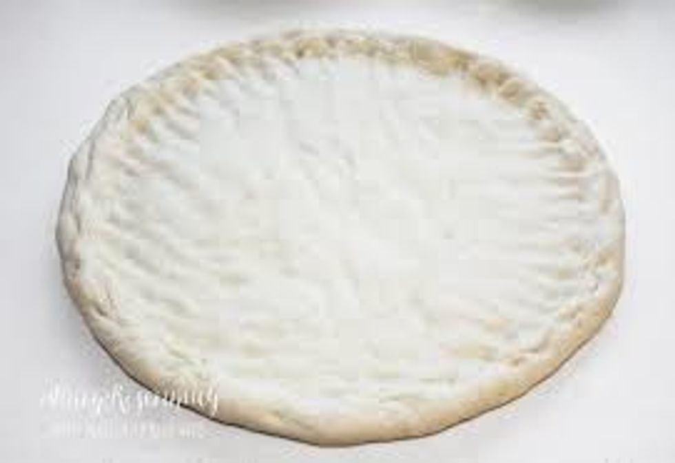 You need dough for your pizza and put it on a cutting board or plate or table and roll it flat.