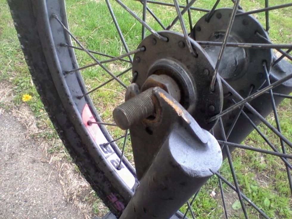 You now have the bike tire off and now you bring in the spare tire and put it on both sides of the forks so the stems line up.