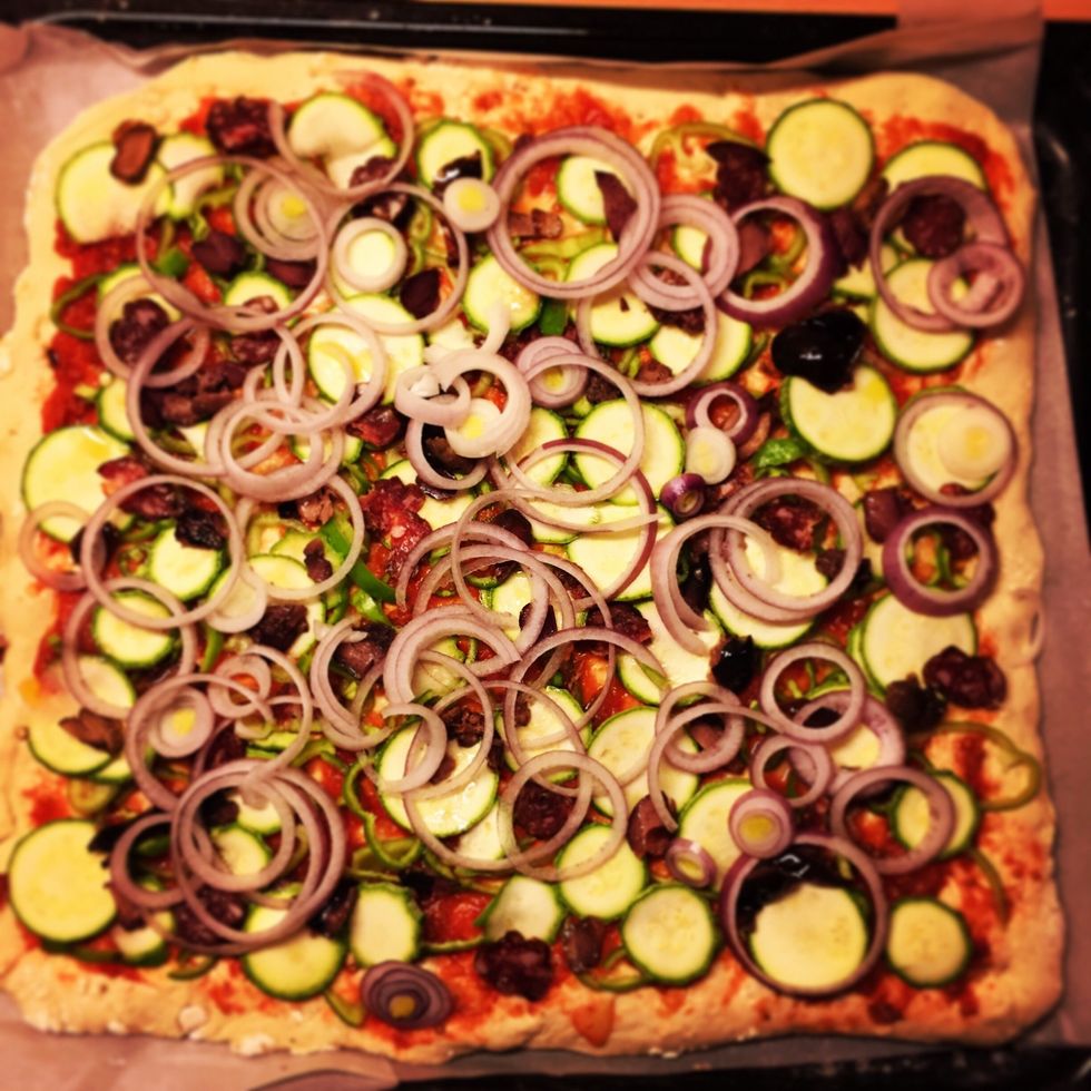 You place the dough on a tray and add topping in fine pieces