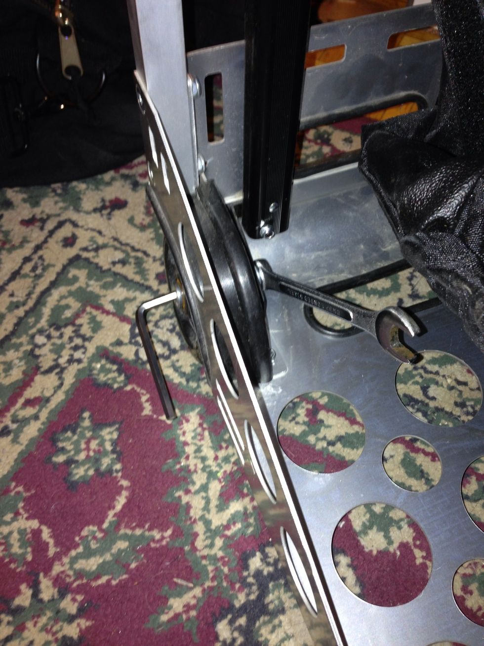 You place the wrench on the locking nut and the Allen Key in the centre of the axel bolt. Use the Allen Key to unscrew the axel bolt from the locking nut and remove the wheel, bolt and hardware.