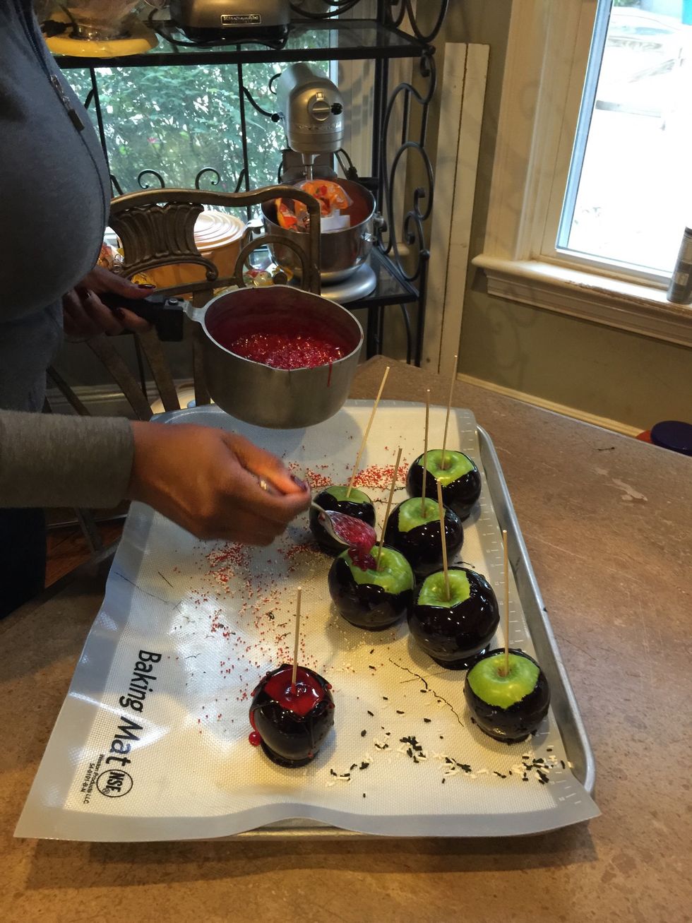 You're going to cook the red mixture the exact way we cooked the black mixture, when it's time to dip, take a spoon and "spill some of the candy" on top of the apples.