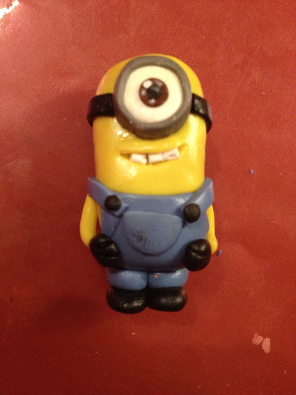 You see? He is glad. Now make a pocket on his chest and two black buttons.