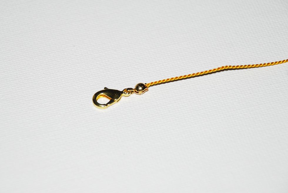 You should end up with your clasp neatly attached at the end of your thread with the clamshell closed tight.