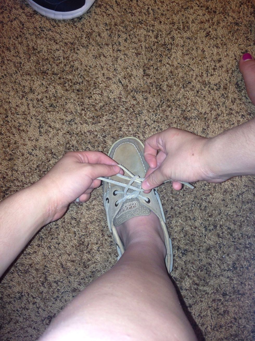 You should have the other lace pulled halfway through the hole underneath the other loop. You are making your second loop.