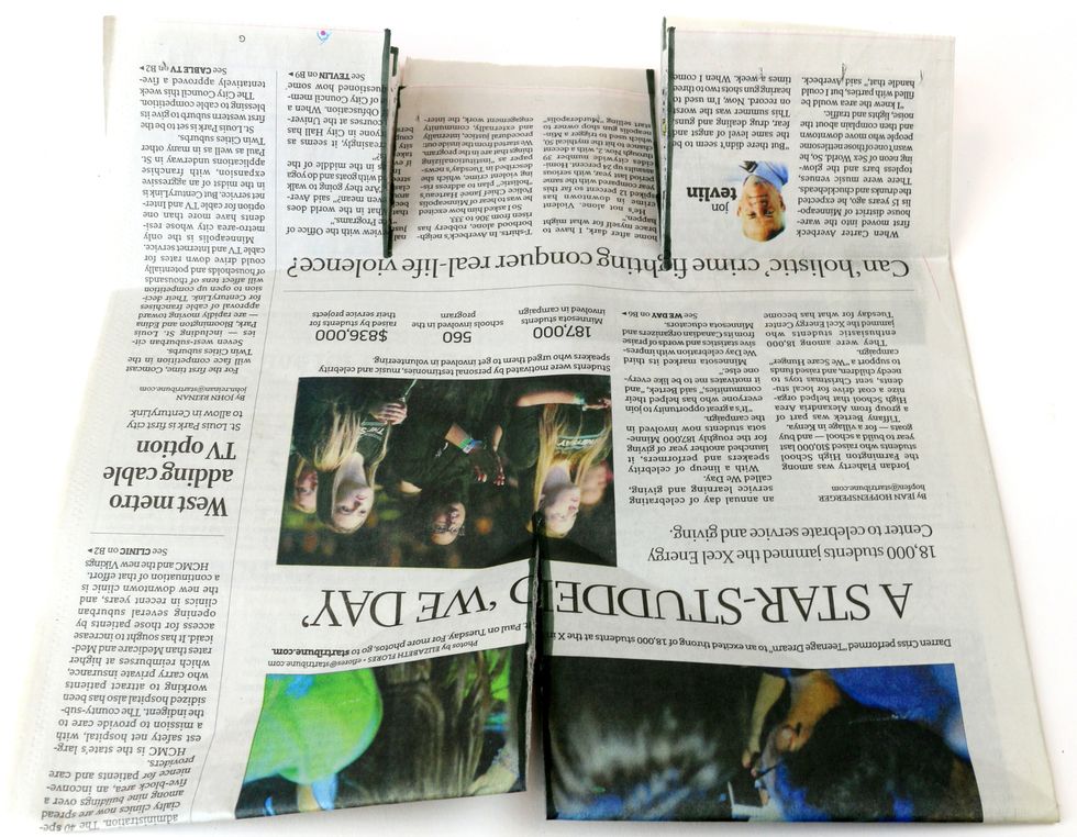 You should now have three flaps on the top and two on the bottom of the newspaper. The top three flaps represent the head and arms, and the bottom two flaps will be the legs.