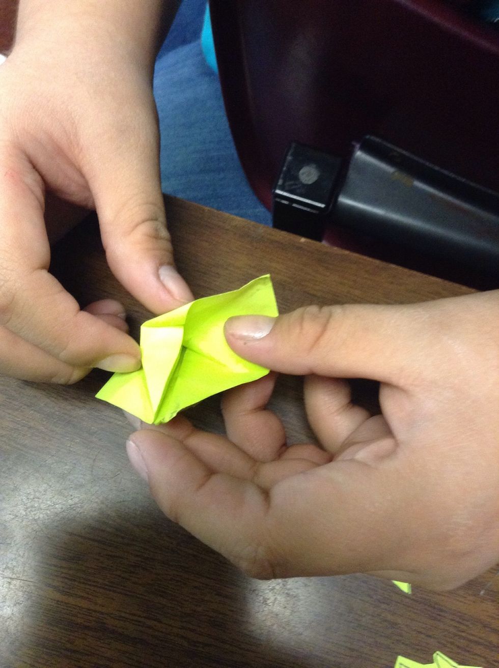 You take the piece of paper that has a crease in it on the side and push it into it.