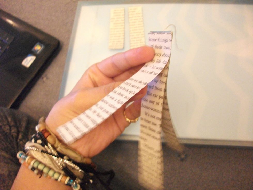 You then take the two SECOND longest strips (10 cm) and 'sandwich' them around the first two. So it would be like: Second longest strip - longest strip - thread - longest strip - second longest strip.