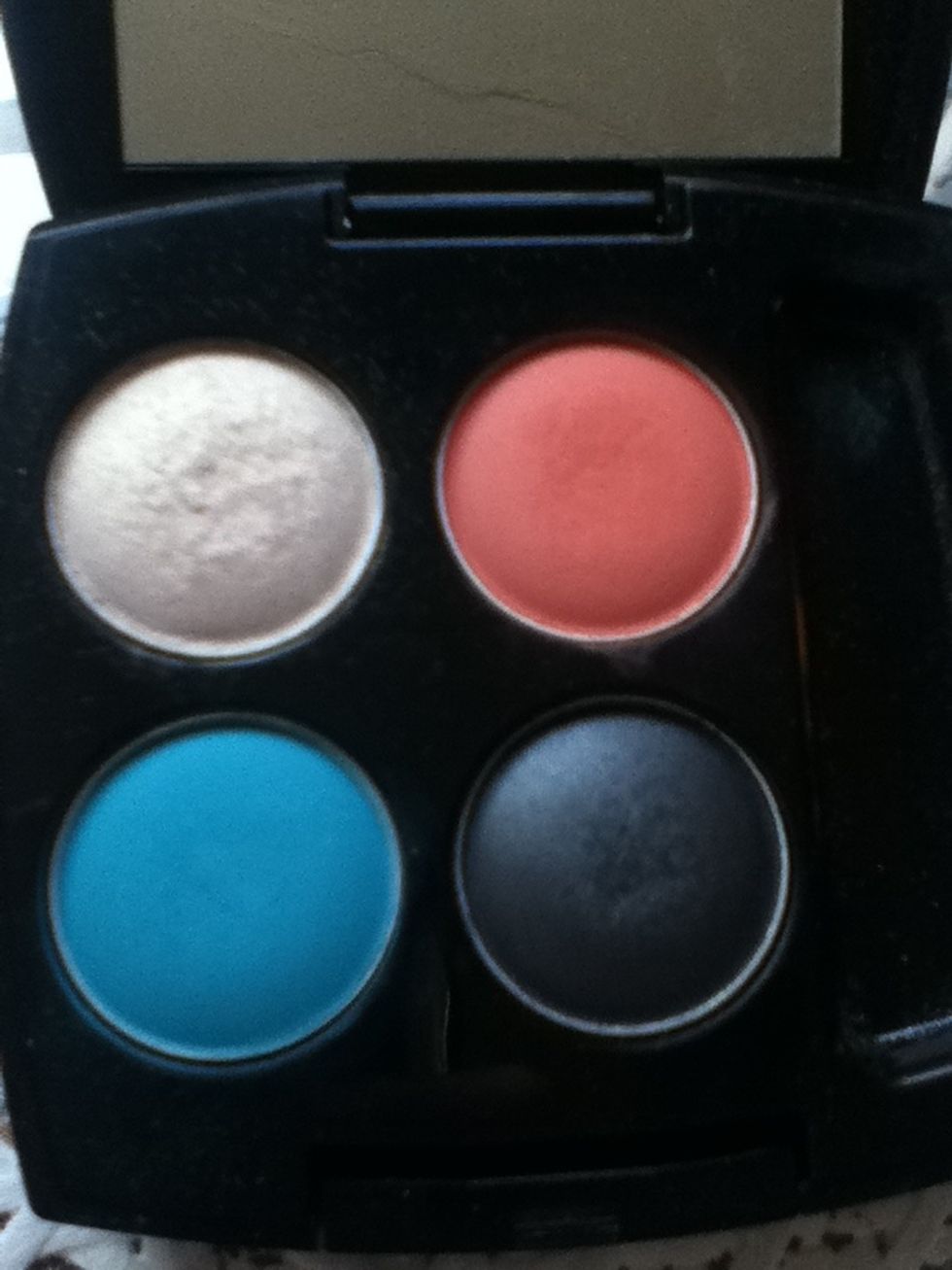 You will need a bright blue, bright coral, black and white eyeshadows for this look. I am using my Avon True Colour Aquadelic pallete.