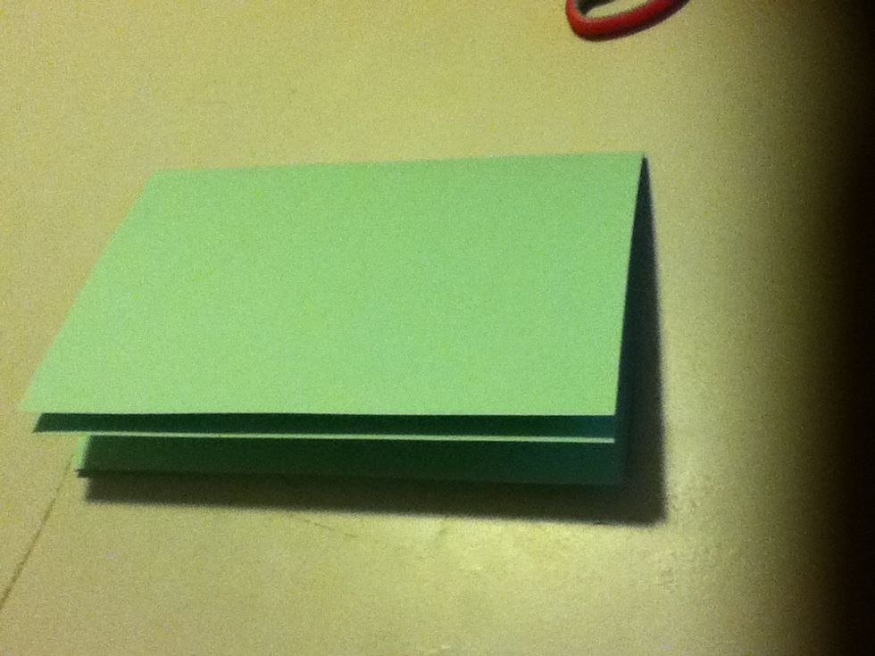 You will need to stack the two pieces of paper together and fold them both in half.