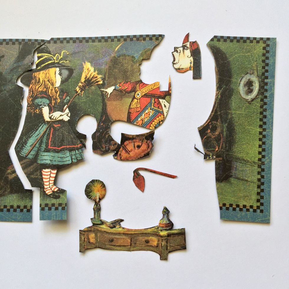 You will need two equal pieces of paper. Fussy cut one of them to get the face, the tail and the brooch of the queen, the furniture, and Alice figure.