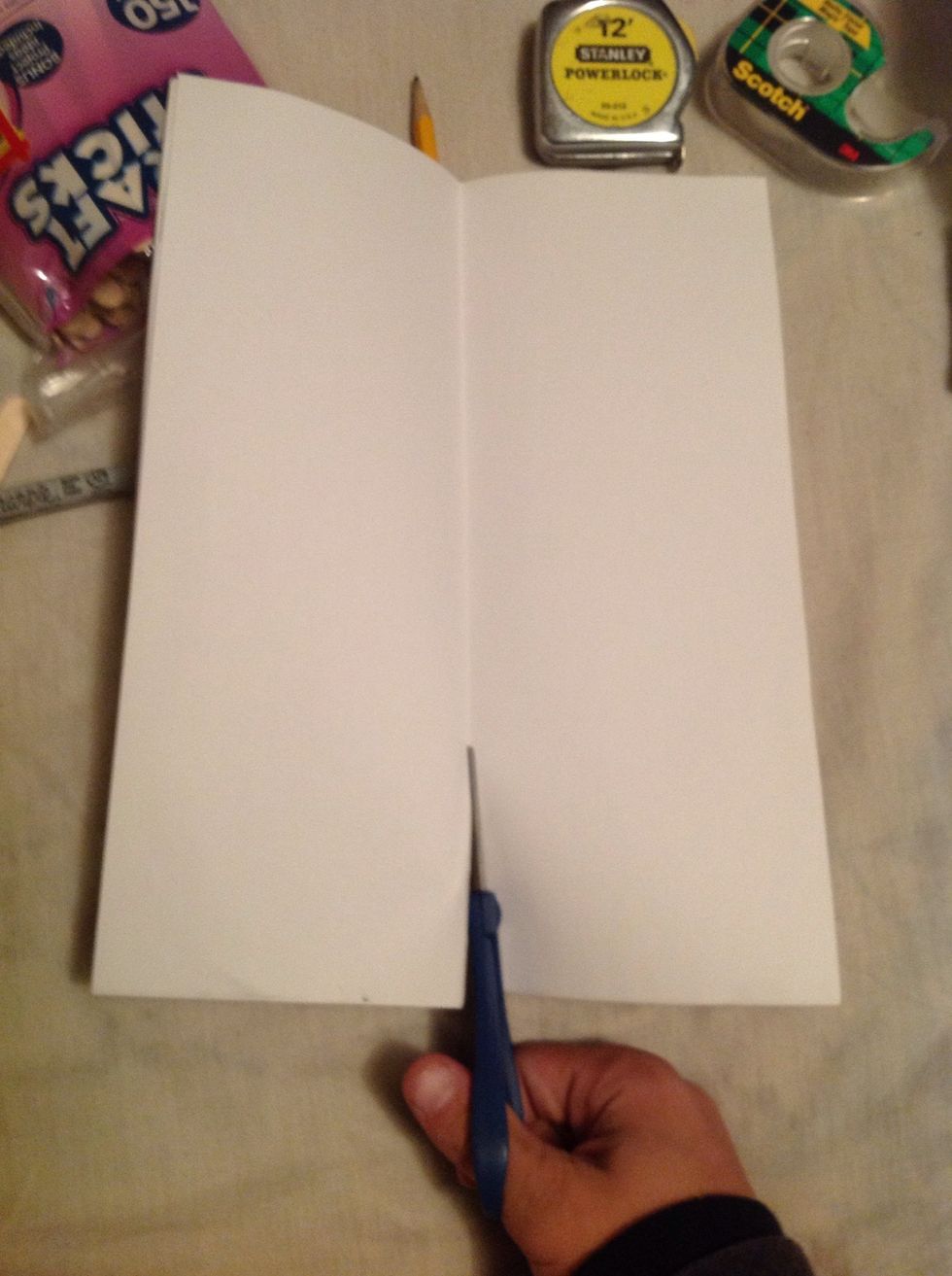 You will unfold the paper and cut along the seem of the paper.