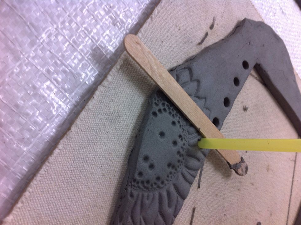 You will use the width of the Popsicle stick to space the holes. I had 10 openings on my frame.