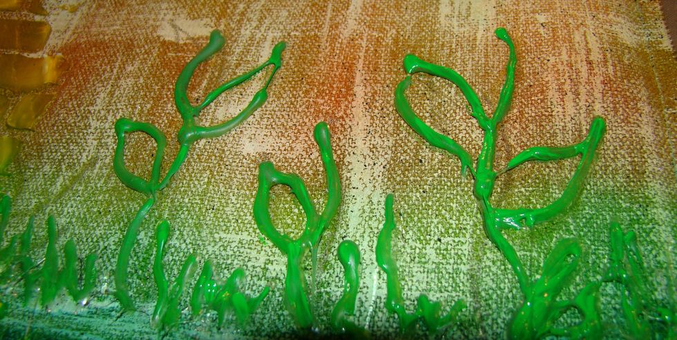 Your glue gun art will be dry now, so take green acrylic paint and paint the stems, leaves, and grass