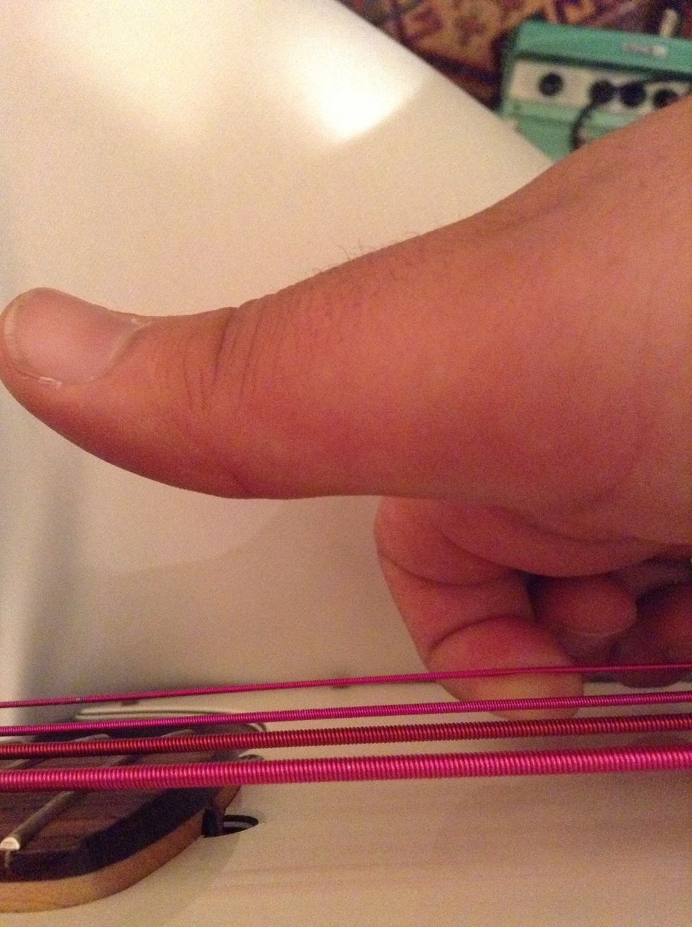 Your index(or prefered finger) should be placed under the string (but not to much) and will be moved in a upwards direction:)