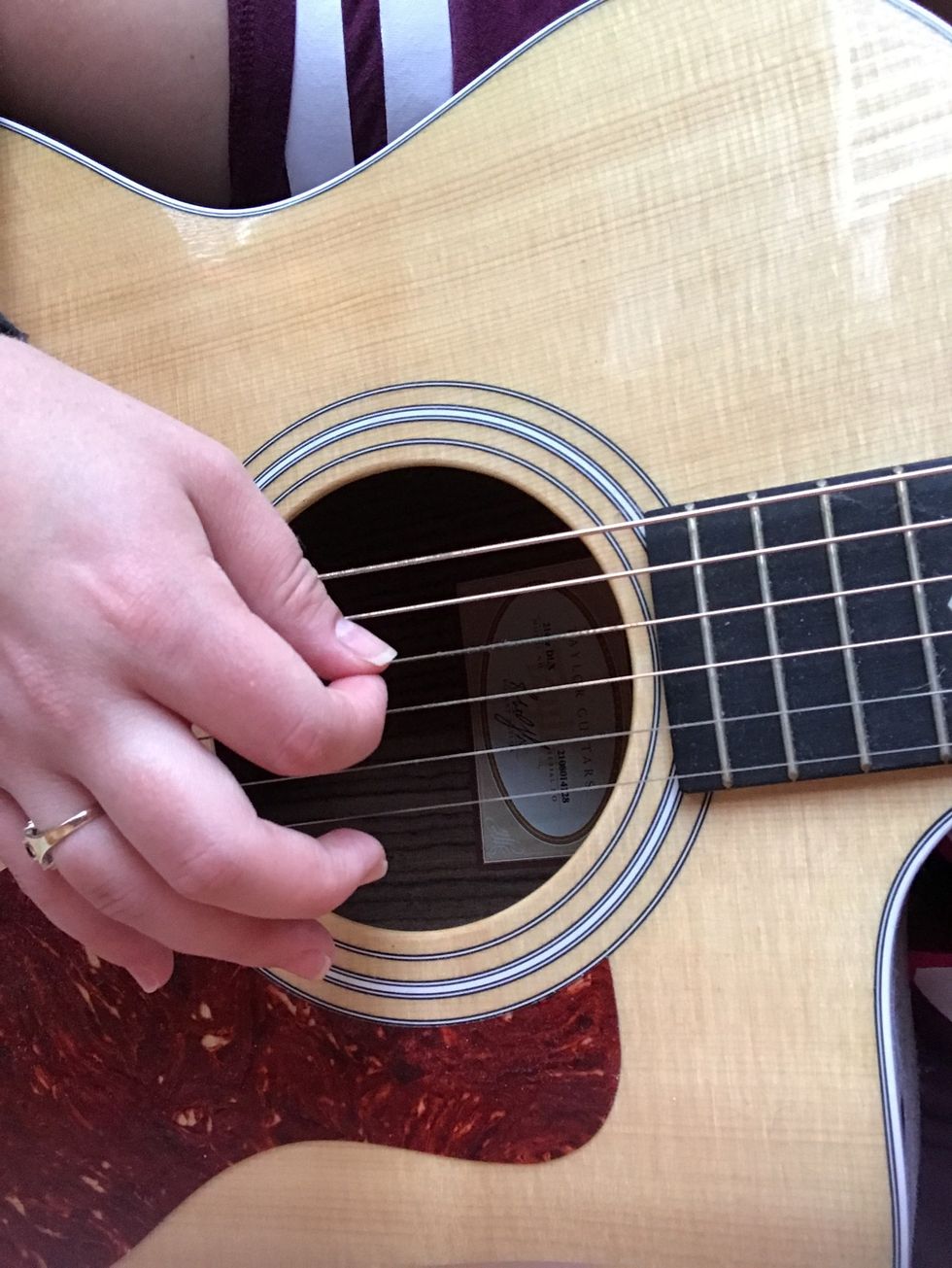 Your right hand should be relaxed and in front of the sound hole, ready to strum.