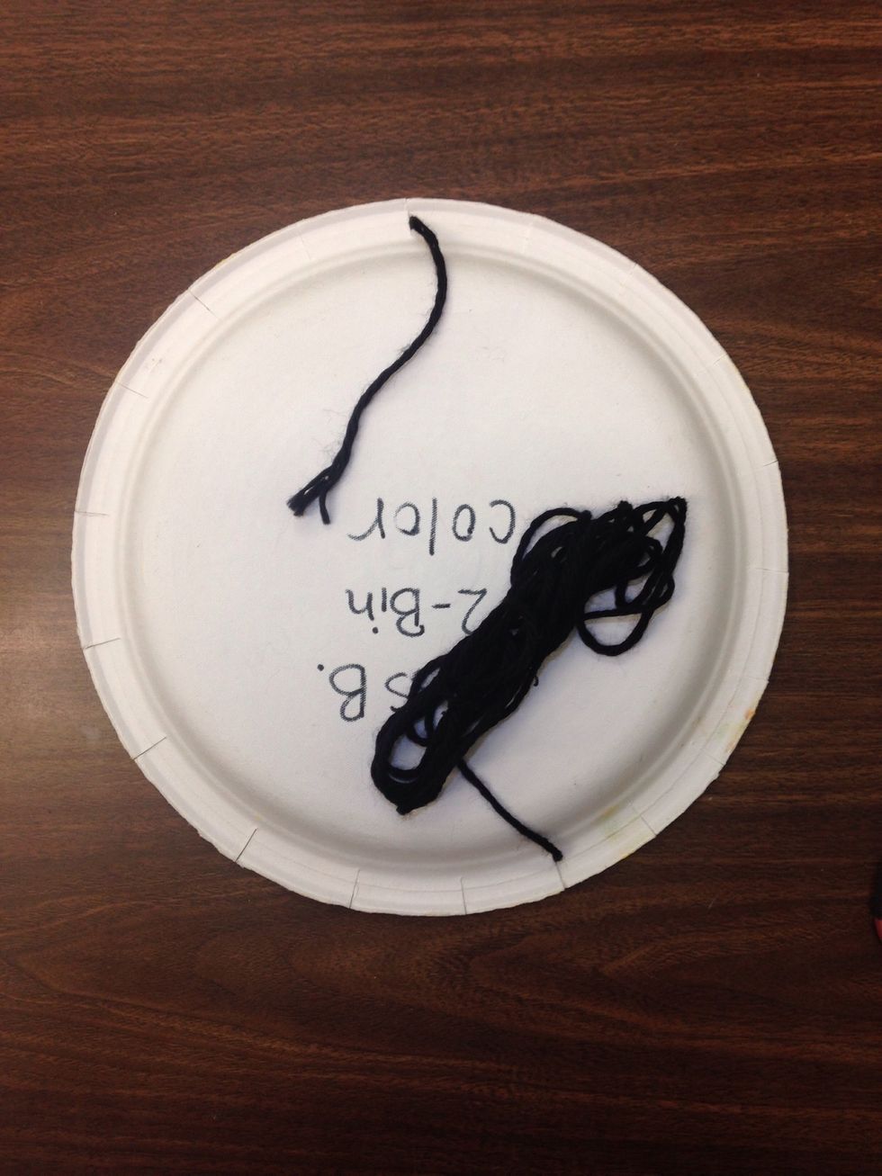 Your yarn should be pulled through to the back. Nothing is crossing the back of the plate!